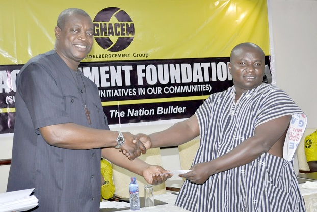 Dr George Dawson-Ahmoah (left) handing over a cement allocation chit to a representative of a beneficiary Institution